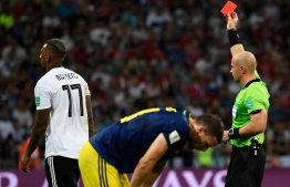 Polish referee Szymon Marciniak (R) presents Germany's defender Jerome Boateng (L) with a red card during the Russia 2018 World Cup Group F football match between Germany and Sweden at the Fisht Stadium in Sochi on June 23, 2018. / AFP PHOTO / Jonathan NACKSTRAND / 