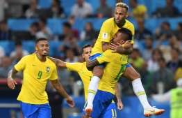 Brazil's midfielder Paulinho (R) celebrates with teammates Brazil's forward Neymar (top), Brazil's forward Gabriel Jesus (L) and Brazil's forward Philippe Coutinho after scoring during the Russia 2018 World Cup Group E football match between Serbia and Brazil at the Spartak Stadium in Moscow on June 27, 2018. / AFP PHOTO / Francisco LEONG / 