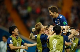 Japan's forward Genki Haraguchi (top) celebrates with teammates after scoring during the Russia 2018 World Cup round of 16 football match between Belgium and Japan at the Rostov Arena in Rostov-On-Don on July 2, 2018. / AFP PHOTO / Odd ANDERSEN / 