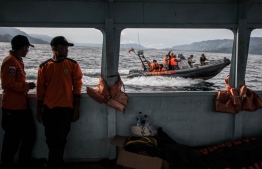 Rescue personnel search the waters where a ferry on June 18 capsized with three passengers confirmed dead and 193 listed as missing, on Lake Toba on June 26, 2018.
A sunken Indonesian ferry could be sitting 450 metres (1,475 feet) below the surface of one the world's deepest lakes, officials said on June 25, raising fears that scores of missing may never be retrieved from their watery grave. / AFP PHOTO / Ivan Damanik