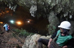 Rescue personnel are seen at the opening of the Tham Luang cave in Khun Nam Nang Non Forest Park in Chiang Rai on June 27, 2018 while operation continue for a missing children's football team and their coach.
The desperate search for 12 children and their football coach trapped since June 23 in a flooded cave in northern Thailand pressed on as distraught relatives prayed and awaited news about the missing youngsters. / AFP PHOTO / LILLIAN SUWANRUMPHA