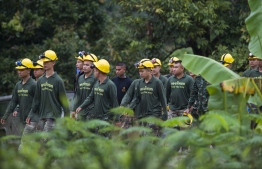 Thai soldiers walk out from the Tham Luang cave area as operations continue for the 8 boys and their coach trapped at the cave in Khun Nam Nang Non Forest Park in the Mae Sai district of Chiang Rai province on July 9, 2018.
Four boys among the group of 13 trapped in a flooded Thai cave for more than a fortnight were rescued on July 8 after surviving a treacherous escape, raising hopes elite divers would also save the others soon. / AFP PHOTO / YE AUNG THU