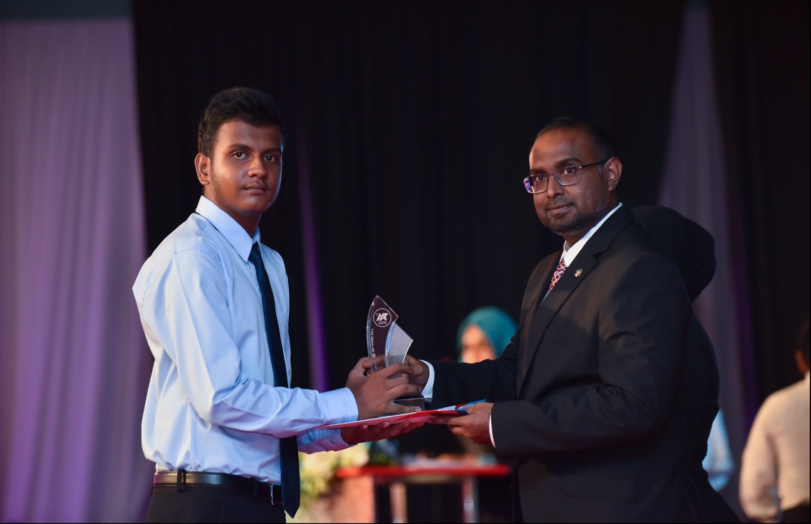 މާލެ: ޖުލައި 9، 2018: މިދިޔަ އަހަރުގެ އޮކްޓޯބަރު/ނޮވެމްބަރުގައި ބޭއްވި އޭ ލެވެލް އިމްތިހާނުން ވަނަތައް ހޯދި ދަރިވަރުންނަށް އެވޯޑު ދިނުމުގެގޮތުން ދަރުބާރުގޭގައި ބޭއްވި ރަސްމިއްޔާތުގައި، ރައީސް އޮފީހުގެ ސްޓޭޓް މިނިސްޓަރު މުޖުތާޒް، ދަރިވަރަކަށް އެވޯޑު ހަވާލުކުރައްވަނީ.--- ފޮޓޯ: ހުސައިން ވަހީދު/މިހާރު