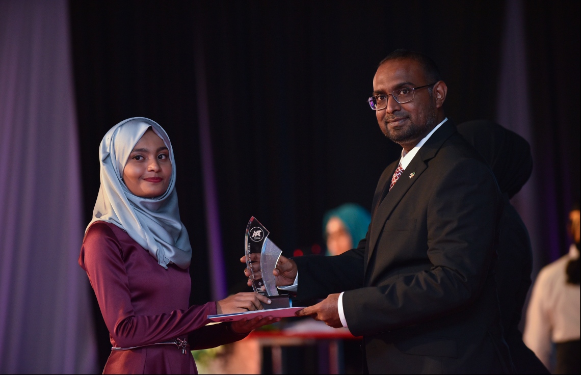 މާލެ: ޖުލައި 9، 2018: މިދިޔަ އަހަރުގެ އޮކްޓޯބަރު/ނޮވެމްބަރުގައި ބޭއްވި އޭ ލެވެލް އިމްތިހާނުން ވަނަތައް ހޯދި ދަރިވަރުންނަށް އެވޯޑު ދިނުމުގެގޮތުން ދަރުބާރުގޭގައި ބޭއްވި ރަސްމިއްޔާތުގައި، ރައީސް އޮފީހުގެ ސްޓޭޓް މިނިސްޓަރު މުޖުތާޒް، ދަރިވަރަކަށް އެވޯޑު ހަވާލުކުރައްވަނީ.--- ފޮޓޯ: ހުސައިން ވަހީދު/މިހާރު