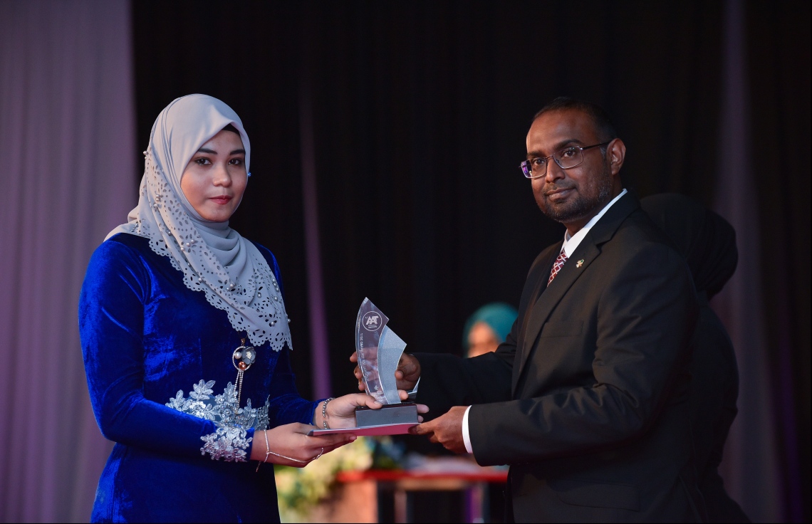 މާލެ: ޖުލައި 9، 2018: މިދިޔަ އަހަރުގެ އޮކްޓޯބަރު/ނޮވެމްބަރުގައި ބޭއްވި އޭ ލެވެލް އިމްތިހާނުން ވަނަތައް ހޯދި ދަރިވަރުންނަށް އެވޯޑު ދިނުމުގެގޮތުން ދަރުބާރުގޭގައި ބޭއްވި ރަސްމިއްޔާތުގައި، ރައީސް އޮފީހުގެ ސްޓޭޓް މިނިސްޓަރު މުޖުތާޒް، ދަރިވަރަކަށް އެވޯޑު ހަވާލުކުރައްވަނީ.--- ފޮޓޯ: ހުސައިން ވަހީދު/މިހާރު