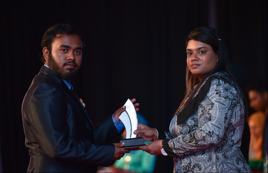 މާލެ: ޖުލައި 9، 2018: މިދިޔަ އަހަރުގެ އޮކްޓޯބަރު/ނޮވެމްބަރުގައި ބޭއްވި އޭ ލެވެލް އިމްތިހާނުން ވަނަތައް ހޯދި ދަރިވަރުންނަށް އެވޯޑު ދިނުމުގެގޮތުން ދަރުބާރުގޭގައި ބޭއްވި ރަސްމިއްޔާތުގައި، ޕްރޮސެކިއުޓާ ޖެނެރަލް އައިޝަތު ބިޝާމް، ދަރިވަރަކަށް އެވޯޑު ހަވާލުކުރައްވަނީ.--- ފޮޓޯ: ހުސައިން ވަހީދު/މިހާރު