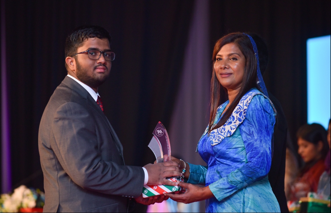 މާލެ: ޖުލައި 9، 2018- މިދިޔަ އަހަރުގެ އޮކްޓޯބަރު/ނޮވެމްބަރުގައި ބޭއްވި އޭ ލެވެލް އިމްތިހާނުގެ ރަންވަނަތައް ހޯދި ދަރިވަރުންނަށް އިނާމު ދިނުމަށް ދަރުބާރުގޭގައި ބޭއްވި ރަސްމިއްޔާތުގައި، އެޑިއުކޭޝަން މިނިސްޓަރު އާއިޝަތު ޝިހާމް، ދަރިވަރަކަށް އެވޯޑާއި އިނާމު ދެއްވަނީ.---ފޮޓޯ: ހުސެއިން ވަހީދު/މިހާރު