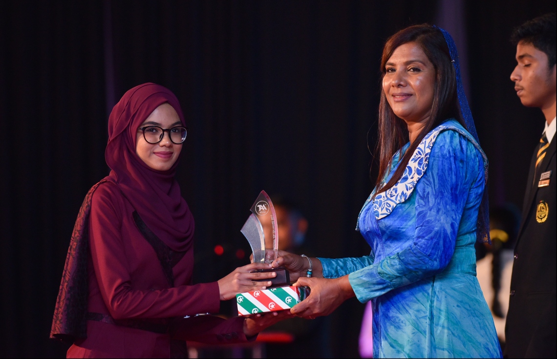 މާލެ: ޖުލައި 9، 2018: މިދިޔަ އަހަރުގެ އޮކްޓޯބަރު/ނޮވެމްބަރުގައި ބޭއްވި އޭ ލެވެލް އިމްތިހާނުން ވަނަތައް ހޯދި ދަރިވަރުންނަށް އެވޯޑު ދިނުމުގެގޮތުން ދަރުބާރުގޭގައި ބޭއްވި ރަސްމިއްޔާތުގައި އެޑިއުކޭޝަން މިނިސްޓަރު އައިޝަތު ޝިހާމު، ދަރިވަރަކަށް އެވޯޑު ހަވާލުކުރައްވަނީ.--- ފޮޓޯ: ހުސައިން ވަހީދު/މިހާރު