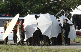 Police and military personnel use umbrellas to cover around a stretcher near a helicopter and an ambulance at a military airport in Chiang Rai on July 9, 2018, as rescue operations continue for those still trapped inside the cave in Khun Nam Nang Non Forest Park in the Mae Sai district.
Four boys among the group of 13 trapped in a flooded Thai cave for more than a fortnight were rescued on July 8 after surviving a treacherous escape, raising hopes elite divers would also save the others soon. / AFP PHOTO / LILLIAN SUWANRUMPHA