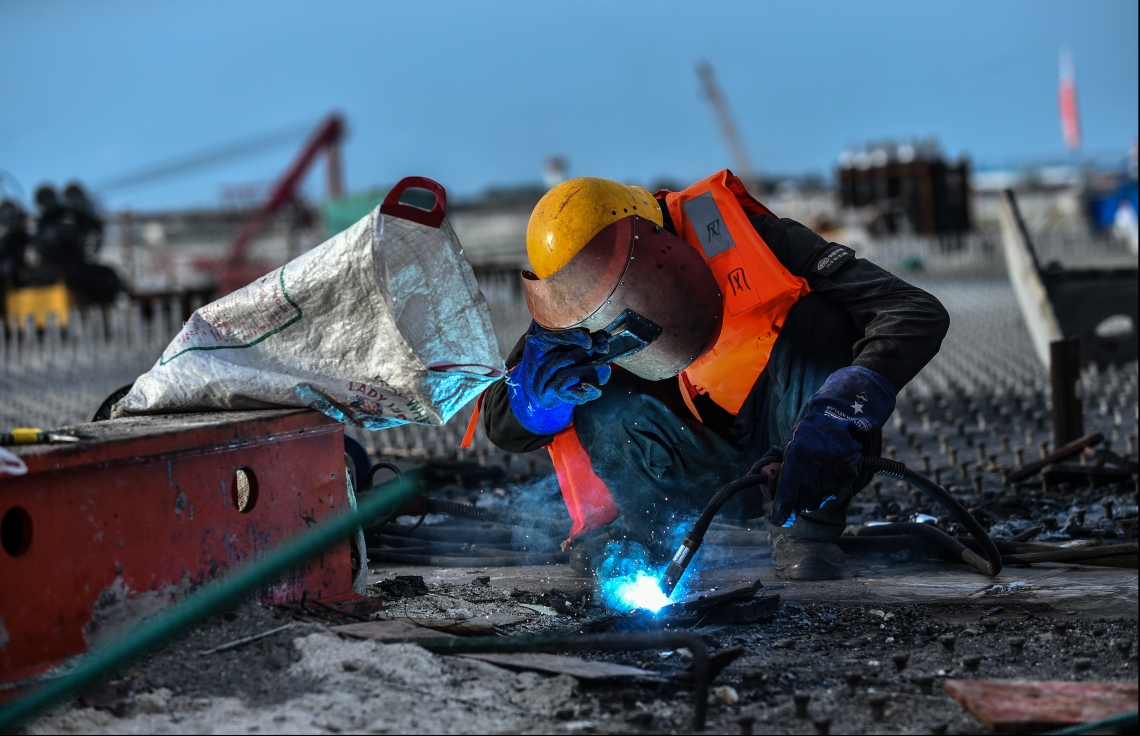 މާލެ: ޖުލައި 12، 2018- މާލެ-ހުޅުލެ ބްރިޖުގެ މަސައްކަތުގައި މީހަކު ހަރަކާތްތެރިވަނީ: މައިގަނޑު ގޮތެއްގައި ދެން އޮތީ ބްރިޖުގައި ތާރު އެޅުން---ފޮޓޯ: ހުސެއިން ވަހީދު/މިހާރު