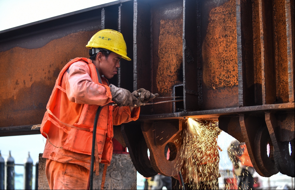 މާލެ: ޖުލައި 12، 2018- މާލެ-ހުޅުލެ ބްރިޖުގެ މަސައްކަތުގައި މީހަކު ހަރަކާތްތެރިވަނީ: ބްރިޖުގެ މައި ހަތް ތަނބު ހުންނައިރު، އެންމެ އުނދަގޫ މަސައްކަތަކަށްވީ، އެ ތަނބުތަކުގައި ޖަހާފައިވާ ބިޔަ 35 ހޮޅި ކަނޑު އަޑި އަށް ފެއްތުން.---ފޮޓޯ: ހުސެއިން ވަހީދު/މިހާރު