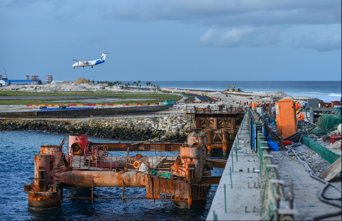މާލެ: ޖުލައި 12، 2018- މާލެ-ހުޅުލެ ބްރިޖުން ހުޅުލެއާ ވީ ކޮޅުގައި މަސައްކަތް ކުރަމުން އަންނައިރު، މޯލްޑިވިއަން ގެ މަތިންދާބޯޓެއް، ވެލާނާ އިންޓަނޭޝަނަލް އެއާޕޯޓަށް ޖައްސަނީ: ބްރިޖާ އެކު މާލެ އާއި ހުޅުލެ އަދި ހުޅުމާލެ އަށް ދިއުމަށް ބޮޑެތި ފަސޭހަތަކެއް ލިބޭނެ.---ފޮޓޯ: ހުސެއިން ވަހީދު/މިހާރު
