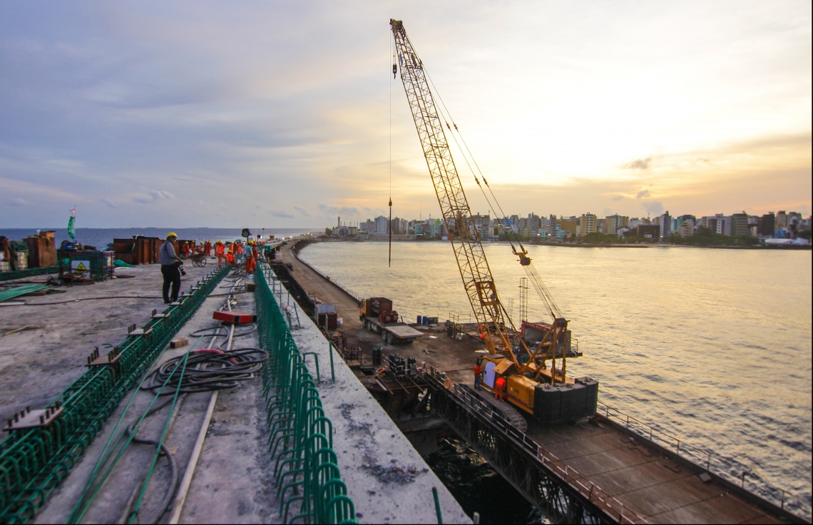 މާލެ: ޖުލައި 12، 2018- މާލެ-ހުޅުލެ ބްރިޖުގެ އެންމެ ފަހުގެ މަސައްކަތްތައް މީޑިއާ އަށް ދައްކާލުން: ވެހިކަލްތަކަށް ޖުމްލަ ހަތަރު ލޭން ބްރިޖުގައި އޮންނާނެ. އެއީ ހުޅުލޭ ކޮޅަށް ޚާއްސަ ދެ ލޭނާއި މާލޭ ކޮޅަށް ދެ ލޭން. މާލޭ ކޮޅުގެ ދެ ލޭންގައި، 3.5 މީޓަރު ހުންނައިރު، އަނެއް ދެ ލޭންގައި 3.2 މީޓަރު ހުންނާނެ ކަމަށް ބްރިޖުގެ މަސައްކަތުގައި އުޅުއްވާ އޮފިޝަލުން ވިދާޅުވޭ. އޭގެ އިތުރުން، ދެ ފަރާތުން ބައިސިކަލް ދުއްވޭވަރުގެ ލޭނެއް ވަނީ ހަދާފައި.---ފޮޓޯ: ހުސެއިން ވަހީދު/މިހާރު