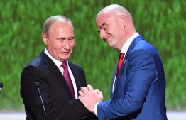 Russian President Vladimir Putin (L) shakes hands with FIFA president Gianni Infantino before a gala concert of world opera stars held at Bolshoi Theatre ahead of the 2018 FIFA World Cup Final match in Moscow on July 14, 2018. / AFP PHOTO / POOL / Yuri KADOBNOV