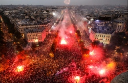 This picture taken from the top of the Arch of Triumph (Arc de Triomphe) on July 15, 2018 shows people lighting flares as they celebrate after France won the Russia 2018 World Cup final football match against Croatia, on the Champs-Elysees avenue in Paris.  / AFP PHOTO / Ludovic MARIN