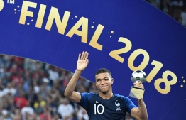 France's forward Kylian Mbappe poses with the FIFA Young Player award during the trophy ceremony at the end of the Russia 2018 World Cup final football match between France and Croatia at the Luzhniki Stadium in Moscow on July 15, 2018. / AFP PHOTO / FRANCK FIFE / 