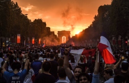People celebrate France's victory in the Russia 2018 World Cup final football match between France and Croatia, on the Champs-Elysees avenue in Paris on July 15, 2018.  / AFP PHOTO / Eric FEFERBERG