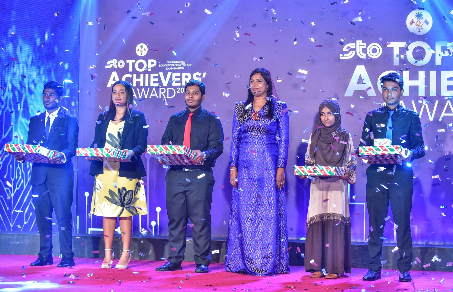 އޯ ލެވެލްއިން އެއް ވަނަ ހޯދި ފަސް ދަރިވަރަކާ އެކު، އޭރުގެ އެޑިއުކޭޝަން މިނިސްޓަރު ޑރ. އައިޝަތު ޝިހާމް ފޮޓޯއަކަށް ހުއްޓިވަޑައިގެން: މިނިސްޓަރާ ޖެހިގެން ކަނާތް ފަރާތުގައި ރިސްލާ -. ފޮޓޯ: ނިޝާން އަލީ/ މިހާރު