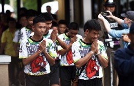 Some of the twelve Thai boys, rescued from a flooded cave after being trapped, arrive to attend a press conference in Chiang Rai on July 18, 2018, following their discharge from the hospital.
The young footballers and their coach appeared healthy when they appeared before the media for the first time on July 18. / AFP PHOTO / Lillian SUWANRUMPHA