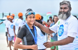 Aishath Saajina is awarded a medal after winning the women's division of the National Open Water Swimming competition held in K.Dhiffushi on July 20, 2018. PHOTO: NISHAN ALI/MIHAARU