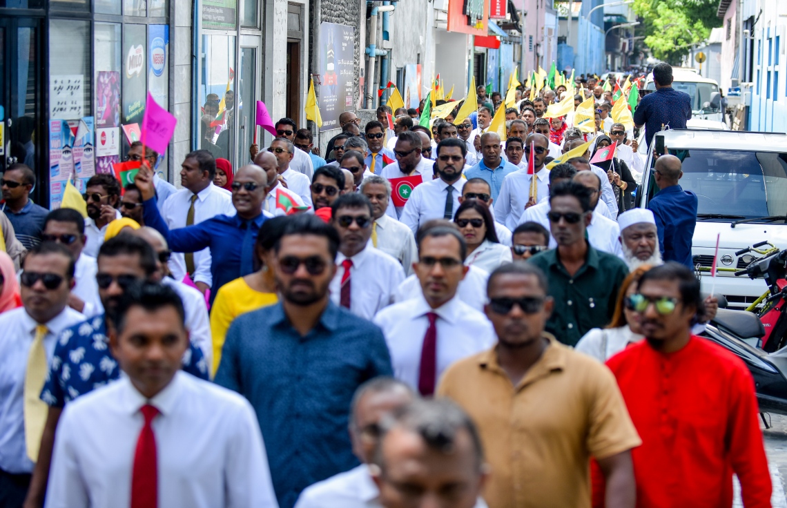 މާލެ: ޖުލައި 26، 2018- މި އަހަރުގެ ރިޔާސީ އިންތިޚާބަށް ކުރިމަތިލެއްވުމަށްޓަކައި އިދިކޮޅު ކެންޑިޑޭޓް އިބްރާހިމް މުހައްމަދު ސޯލިހް (އިބޫ) އާއި އޭނާގެ ރަނިންމޭޓް ފައިސަލް ނަސީމްގެ ފޯމު ހުށަހެޅުއްވުމަށްޓަކައި، އެމްޑީޕީގެ އޮފީހުން ފެށިގެން އިލެކްޝަންސް ކޮމިޝަނާ ހަމައަށް އިދިކޮޅު ކޯލިޝަންގެ ސަޕޯޓަރުންނާ އެކު ހިންގަވާފައި ވަޑައިގަންނަވަނީ.---ފޮޓޯ: އަހުމަދު ނިޝާތު/މިހާރު