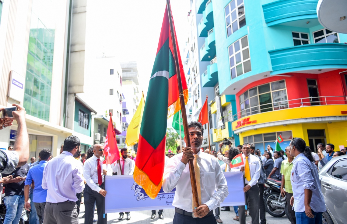 މާލެ: ޖުލައި 26، 2018- މި އަހަރުގެ ރިޔާސީ އިންތިޚާބަށް ކުރިމަތިލެއްވުމަށްޓަކައި އިދިކޮޅު ކެންޑިޑޭޓް އިބްރާހިމް މުހައްމަދު ސޯލިހް (އިބޫ) އާއި އޭނާގެ ރަނިންމޭޓް ފައިސަލް ނަސީމްގެ ފޯމު ހުށަހެޅުއްވުމަށްޓަކައި، ބޭއްވި ހަރަކާތުގައި އެމްޑީޕީގެ ނައިބު ރައީސް މުހައްމަދު ޝިފާޒް ގައުމީ ދިދަ ހިއްޕަވައިގެން ބައިވެރިވެވަޑައިގަންނަވަނީ.--ފޮޓޯ: އަހުމަދު ނިޝާތު/މިހާރު