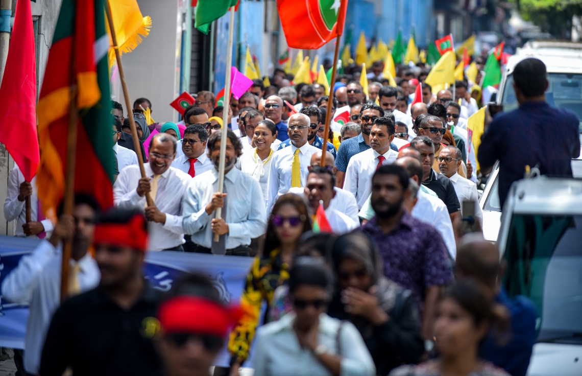 މާލެ: ޖުލައި 26، 2018- މި އަހަރުގެ ރިޔާސީ އިންތިޚާބަށް ކުރިމަތިލެއްވުމަށްޓަކައި އިދިކޮޅު ކެންޑިޑޭޓް އިބްރާހިމް މުހައްމަދު ސޯލިހް (އިބޫ) އާއި އޭނާގެ ރަނިންމޭޓް ފައިސަލް ނަސީމްގެ ފޯމު ހުށަހެޅުއްވުމަށްޓަކައި، އެމްޑީޕީގެ އޮފީހުން ފެށިގެން އިލެކްޝަންސް ކޮމިޝަނާ ހަމައަށް އިދިކޮޅު ކޯލިޝަންގެ ސަޕޯޓަރުންނާ އެކު ހިންގަވާފައި ވަޑައިގަންނަވަނީ.---ފޮޓޯ: އަހުމަދު ނިޝާތު/މިހާރު