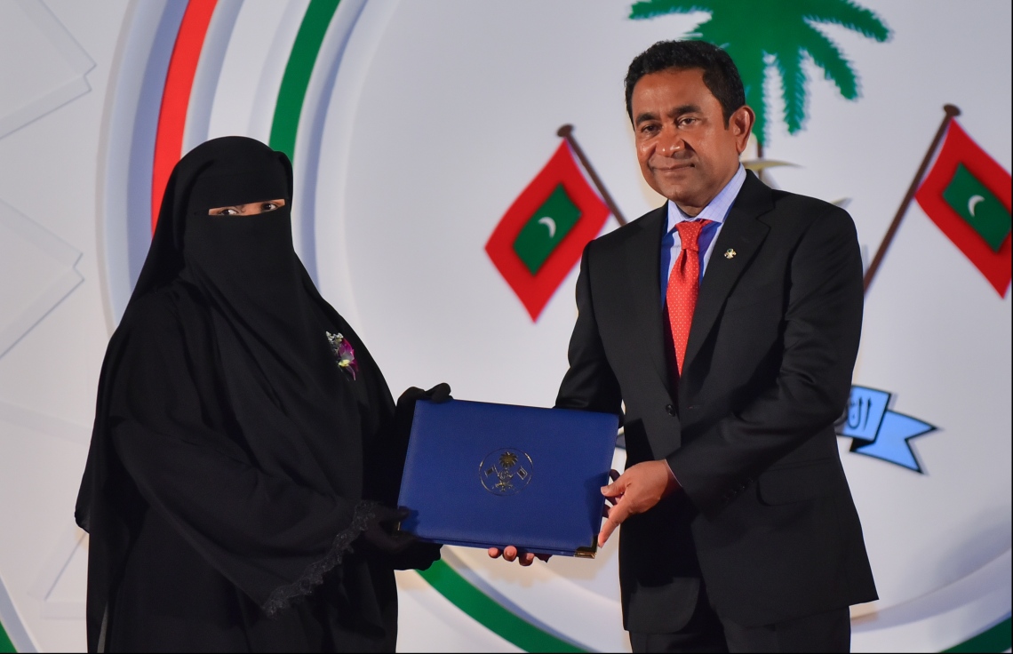 މާލެ: ޖުލައި 26، 2018- ރާއްޖޭގެ މިނިވަން ކަމަށް 53 އަހަރު ފުރުން ފާހަގަ ކުރުމަށް ޖުމްހޫރީ މައިދާނުގައި ބޭއްވި ރަސްމިއްޔާތުގައި، ގުރުއާން ހިތުދަސް ކުރި ހާފިޒަކަށް ރައީސް ޔާމީން އިނާމު ދެއްވަނީ.---ފޮޓޯ: ހުސައިން ވަހީދު/މިހާރު