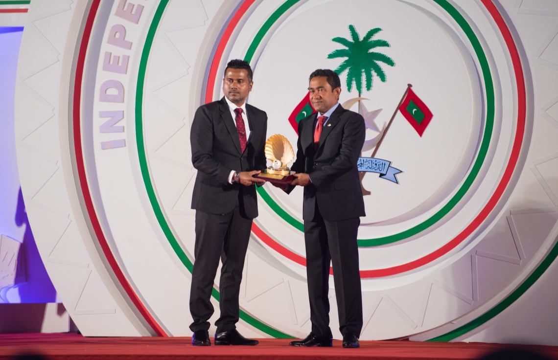 މާލެ: ޖުލައި 26، 2018- ރާއްޖޭގެ މިނިވަން ކަމަށް 53 އަހަރު ފުރުން ފާހަގަ ކުރުމަށް ޖުމްހޫރީ މައިދާނުގައި ބޭއްވި ރަސްމިއްޔާތުގައި، މަސައްކަތްތެރިކަމުގެ ދާއިރާއިން އަލްމަރުހޫމު މުހައްމަދު ޝާކިރުގެ ހަނދާނަށް ދެއްވި ޝަރަފުވެރިކަމުގެ ގައުމީ އިނާމު، ޝާކިރުގެ ދަރިކަލަކަށް ރައީސް ޔާމީން ހަވާލުކުރައްވަނީ.---ފޮޓޯ: ހުސައިން ވަހީދު/މިހާރު