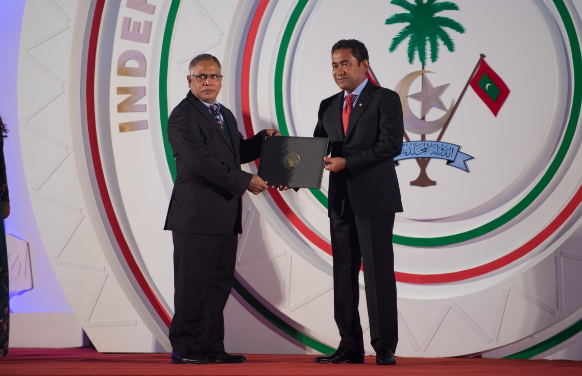 މާލެ: ޖުލައި 26، 2018- ރާއްޖޭގެ މިނިވަން ކަމަށް 53 އަހަރު ފުރުން ފާހަގަ ކުރުމަށް ޖުމްހޫރީ މައިދާނުގައި ބޭއްވި ރަސްމިއްޔާތުގައި، ދިވެހި ބަހާއި އަދަބިއްޔާތުގެ ދާއިރާއިން އަބްދުއްރަޝީދު އަލީ އަށް ރައީސް ޔާމީން ހިތްވަރުދިނުމުގެ ގައުމީ އިނާމު ދެއްވަނީ.---ފޮޓޯ: ހުސައިން ވަހީދު/މިހާރު