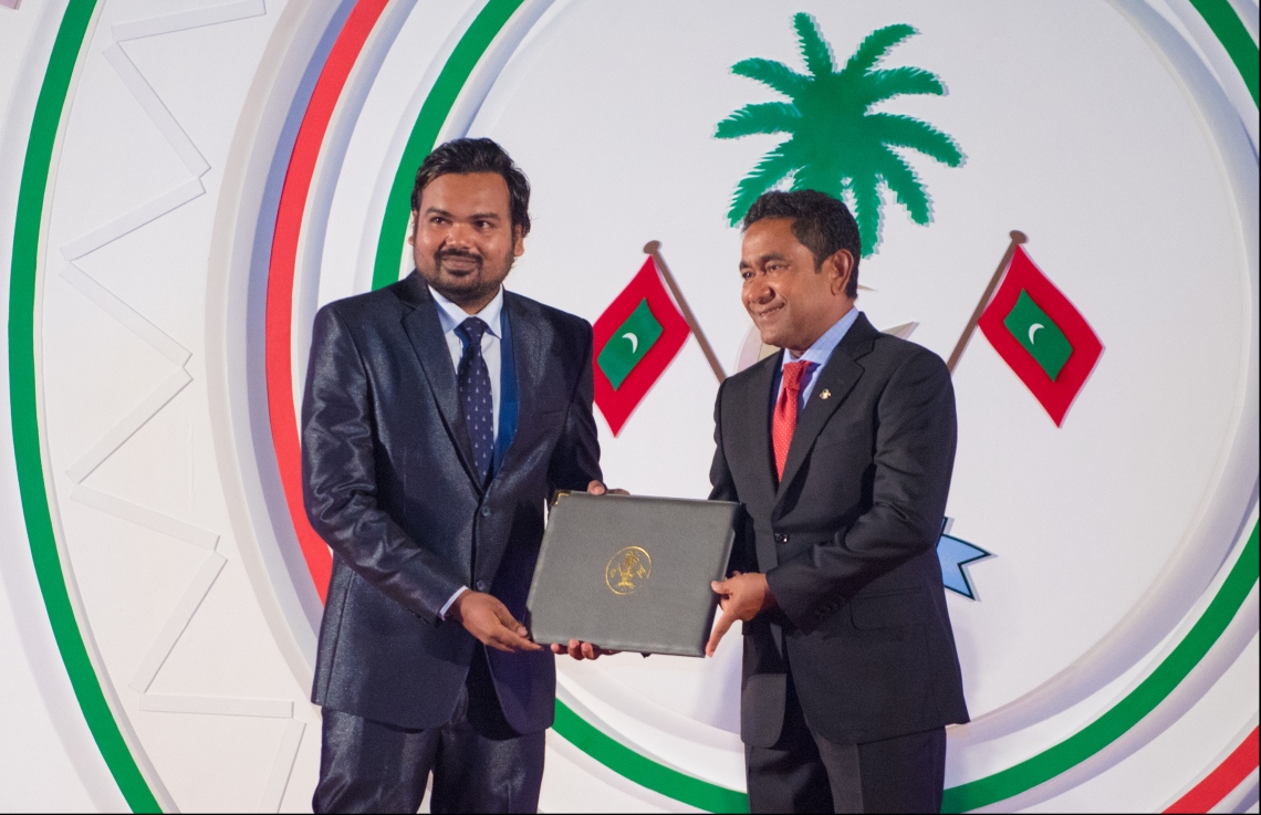 މާލެ: ޖުލައި 26، 2018- ރާއްޖޭގެ މިނިވަން ކަމަށް 53 އަހަރު ފުރުން ފާހަގަ ކުރުމަށް ޖުމްހޫރީ މައިދާނުގައި ބޭއްވި ރަސްމިއްޔާތުގައި، ވިޒުއަލް އާޓްސް ގެ ދާއިރާއިން އަހުމަދު ޝިނާން އަށް ރައީސް ޔާމީން، ހިތްވަރުދިނުމުގެ ގައުމީ އިނާމު ދެއްވަނީ.---ފޮޓޯ: ހުސައިން ވަހީދު/މިހާރު