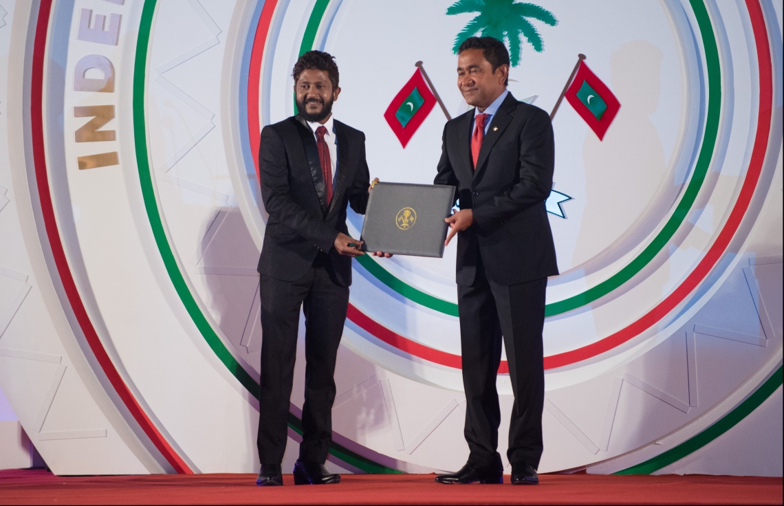 މާލެ: ޖުލައި 26، 2018- ރާއްޖޭގެ މިނިވަން ކަމަށް 53 އަހަރު ފުރުން ފާހަގަ ކުރުމަށް ޖުމްހޫރީ މައިދާނުގައި ބޭއްވި ރަސްމިއްޔާތުގައި، ޕާފޯމިން އާޓްްގެ ދާއިރާއިން އިބްރާހިމް ޒައިދު އަލީ (ކުޑަ އިއްބެ) އަށް ރައީސް ޔާމީން ހިތްވަރުދިނުމުގެ ގައުމީ އިނާމު ދެއްވަނީ.---ފޮޓޯ: ހުސައިން ވަހީދު/މިހާރު