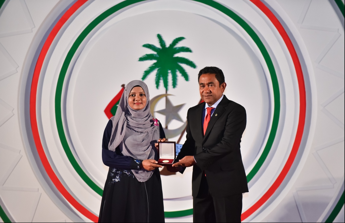 މާލެ: ޖުލައި 26، 2018- ރާއްޖޭގެ މިނިވަން ކަމަށް 53 އަހަރު ފުރުން ފާހަގަ ކުރުމަށް ޖުމްހޫރީ މައިދާނުގައި ބޭއްވި ރަސްމިއްޔާތުގައި، ގުރުއާން ހިތުދަސްކުރި ހާފިޒަކަށް ރައީސް ޔާމީން އިނާމު ދެއްވަނީ.---ފޮޓޯ: ހުސައިން ވަހީދު/މިހާރު