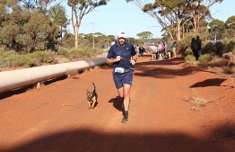 This handout photo taken on July 29, 2018 and received from Rhea Wholey on June 31 shows a dog called Stormy competing in the Goldfields Pipeline marathon near Kalgoorlie.
A stray dog called Stormy has been awarded a medal after completing a half-marathon in outback Australia and winning the hearts of its human competitors. The crossbreed diligently ran the 21-kilometre (13-mile) Goldfields Pipeline Marathon near the West Australian town of Kalgoorlie this month in two-and-a-half hours, the average time of participants.
 / AFP PHOTO / RHEA WHOLEY / RHEA  WHOLEY / RESTRICTED TO EDITORIAL USE - MANDATORY CREDIT "AFP PHOTO / RHEA WHOLEY" - NO MARKETING NO ADVERTISING CAMPAIGNS - DISTRIBUTED AS A SERVICE TO CLIENTS == NO ARCHIVE

