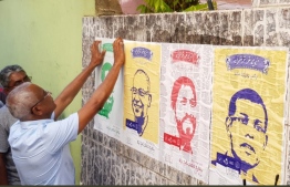 Opposition presidential candidate Ibrahim "Ibu" Mohamed Solih pictured hanging up posters of coalition leaders during his campaign. PHOTO/SOCIAL MEDIA