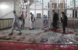 Afghan residents walk inside a damaged mosque after a suicide attack during Friday prayers in Gardez of Paktia province on August 3, 2018. 
Burqa-clad suicide bombers struck a Shiite mosque in eastern Afghanistan Friday as it was crowded with worshippers for weekly prayers, killing at least 29 people and wounding more than 80 in the latest attack on the minority. / AFP PHOTO / FARID ZAHIR