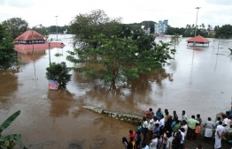 Indian residents look at the Shiva Temple submerged after the release of water from Idamalayar dam following heavy rains in Kochi on August 9, 2018.
At least 20 people were killed on August 9 in landslides triggered by heavy rains in southern India, an official said, pushing the nationwide monsoon death toll for this year to over 700. / AFP PHOTO / -