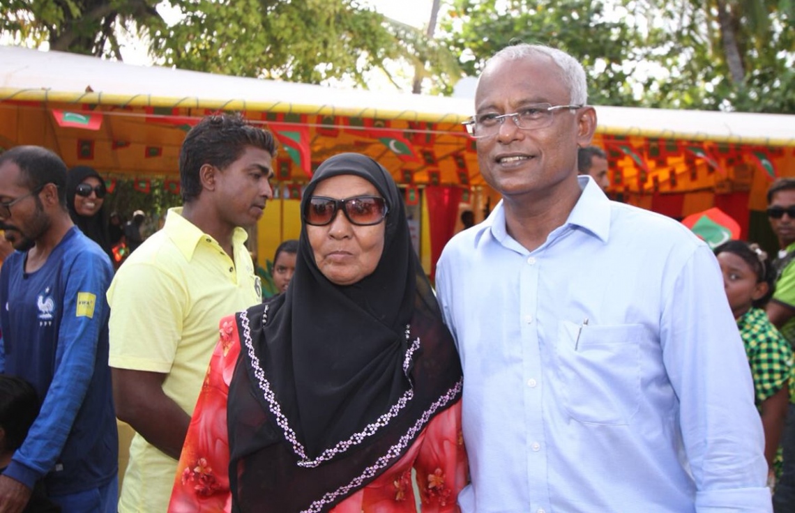 މި އަހަރުގެ ރިޔާސީ އިންތިޚާބުގެ ކެމްޕެއިނަށް އިދިކޮޅު ރިޔާސީ ކެންޑިޑޭޓް އިބްރާހިމް މުހައްމަދު ސޯލިހް (އިބޫ) ހދ. ގެ ރަށްތަކަށް ކުރައްވަމުން ގެންދަވާ ދަތުރުގެ ތެރެއިން، ކުޅުދުއްފުއްޓަށް ވަޑައިގެން އެ ރަށުގެ މީހަކާ އެކު ފޮޓޯއެއް ނަންގަވަނީ.---ފޮޓޯ: އެމްޑީޕީ ޓުވިޓާ