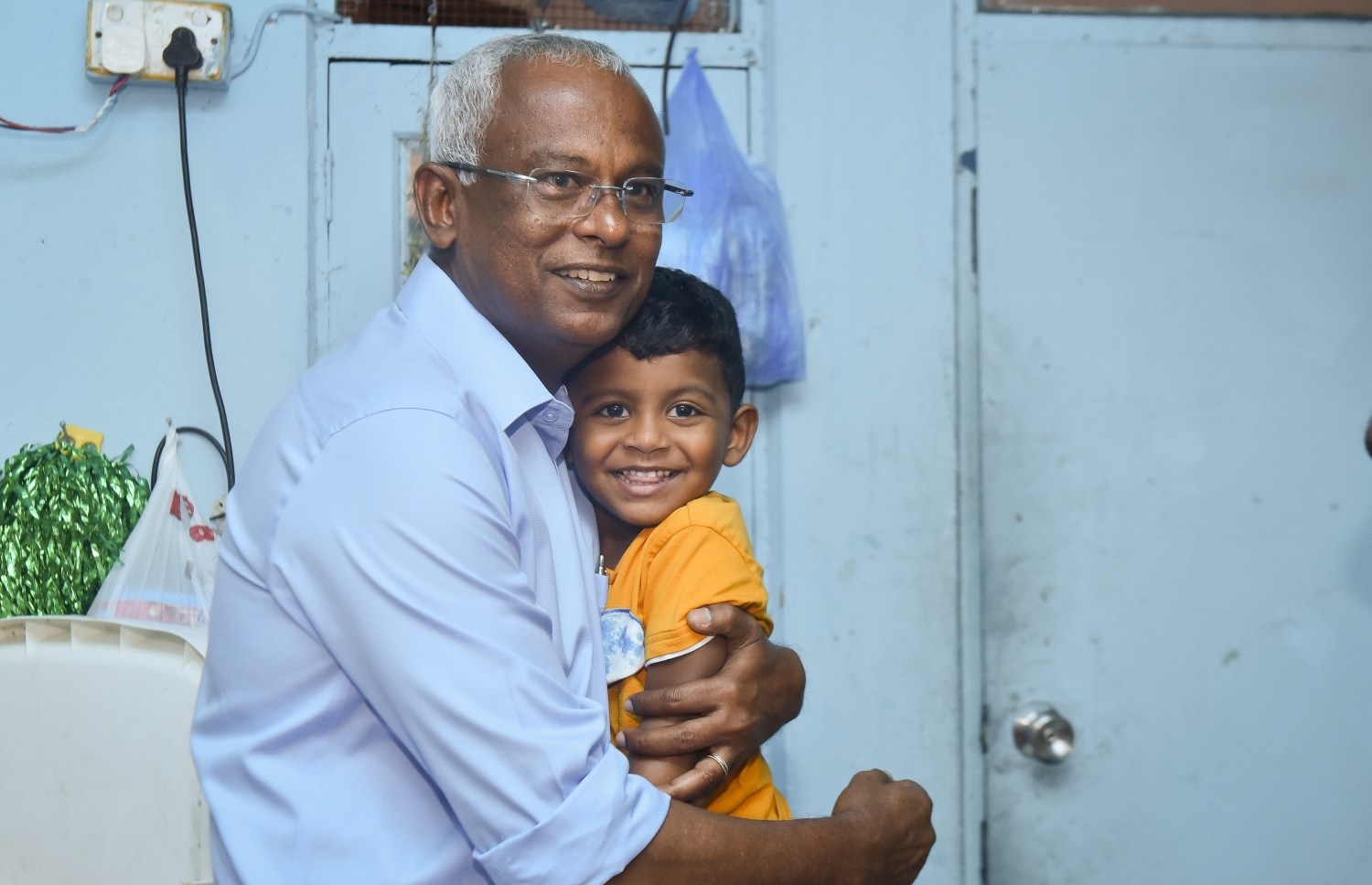 ގަލޮޅު ދެކުނުގައި އިއްޔެ ކުރިއަށް ގެންދިޔަ "ދޮރުން ދޮރަށް" ކެމްޕެއިންގައި އިބޫއާ އެކު ކުޑަކުއްޖަކު ފޮޓޯއެއް ނަގަނީ. -- ފޮޓޯ: ނިޝާން އަލީ/މިހާރު