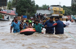 Indian volunteers and rescue personal evacuate local residents in a boat in a residential area at Aluva in Ernakulam district, in the Indian state of Kerala on August 17, 2018.
The death toll from floods that have triggered landslides and sent torrents sweeping through villages in the Indian state of Kerala trebled on August 17 to 324, authorities said, amid warnings of worse weather to come. / AFP PHOTO / -