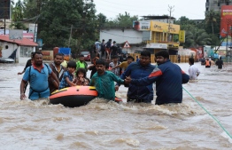 Rescuers in helicopters and boats fought through renewed torrential rain on August 18 to reach stranded villages in India's Kerala state as the toll from the worst monsoon floods in a century rose above 320 dead. / AFP PHOTO / -