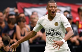 Paris Saint-Germain's French forward Kylian Mbappe celebrates after scoring during the French L1 football match between Guingamp and Paris Saint-Germain, at the Roudourou stadium in Guingamp on August 18, 2018. / AFP PHOTO / FRED TANNEAU