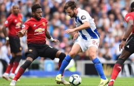 Brighton's Dutch midfielder Davy Propper (C) shields the ball from Manchester United's Brazilian midfielder Fred (L) during the English Premier League football match between Brighton and Hove Albion and Manchester United at the American Express Community Stadium in Brighton, southern England on August 19, 2018. / AFP PHOTO / Glyn KIRK / RESTRICTED TO EDITORIAL USE. No use with unauthorized audio, video, data, fixture lists, club/league logos or 'live' services. Online in-match use limited to 120 images. An additional 40 images may be used in extra time. No video emulation. Social media in-match use limited to 120 images. An additional 40 images may be used in extra time. No use in betting publications, games or single club/league/player publications. / 