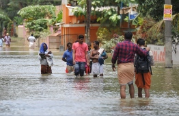 Indian residents walk through flood waters in Pandanad in Alappuzha District in the south Indian state of Kerala on August 21, 2018.
More than one million people have swarmed relief camps in India's Kerala state to escape devastating monsoon floods that have killed more than 410 people, officials said Tuesday as a huge international aid operation gathered pace. / AFP PHOTO / MANJUNATH KIRAN