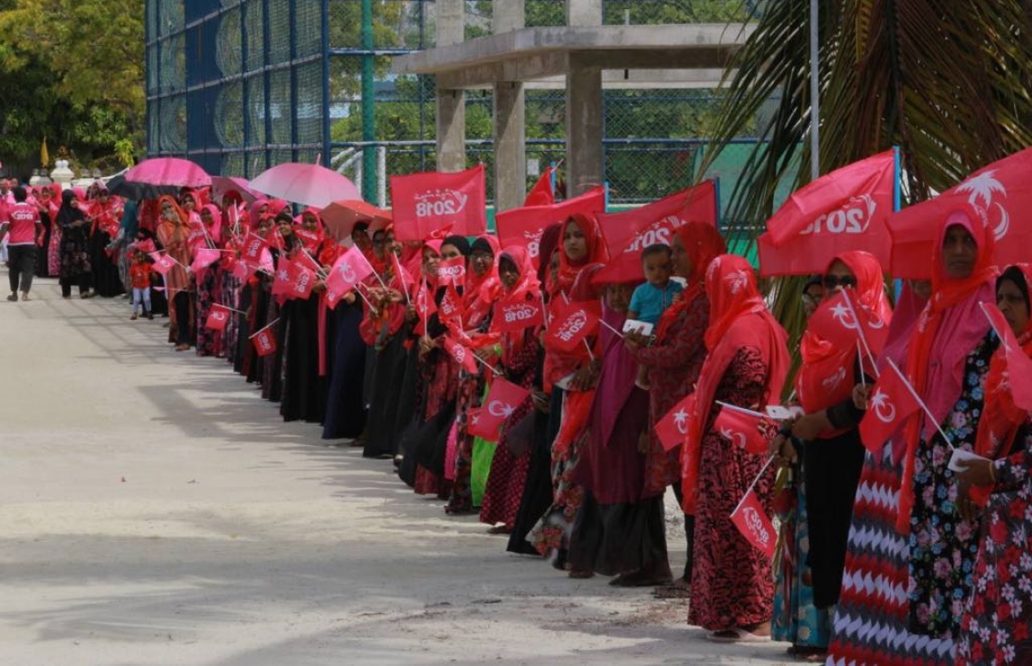 ލ. އަތޮޅު: އޮގަސްޓް 26، 2018: ޕީޕީއެމްގެ ރިޔާސީ ކެންޑިޑޭޓް ރައީސް ޔާމީންގެ ރަނިންމޭޓް ޑރ. ޝަހީމް މި އަތޮޅުގެ ރަށަކަށް ވަޑައިގަތުމުން މަރުހަބާ ދަންނަވަން އެއްވެ ތިބި ބަޔަކު "ރައީސް ޔާމީން 2018" ޖަހާފައިވާ ކުޑަ އާއި ދިދަ ހިފައިގެން ކިޔޫގައި.---ފޮޓޯ: ޕީޕީއެމް