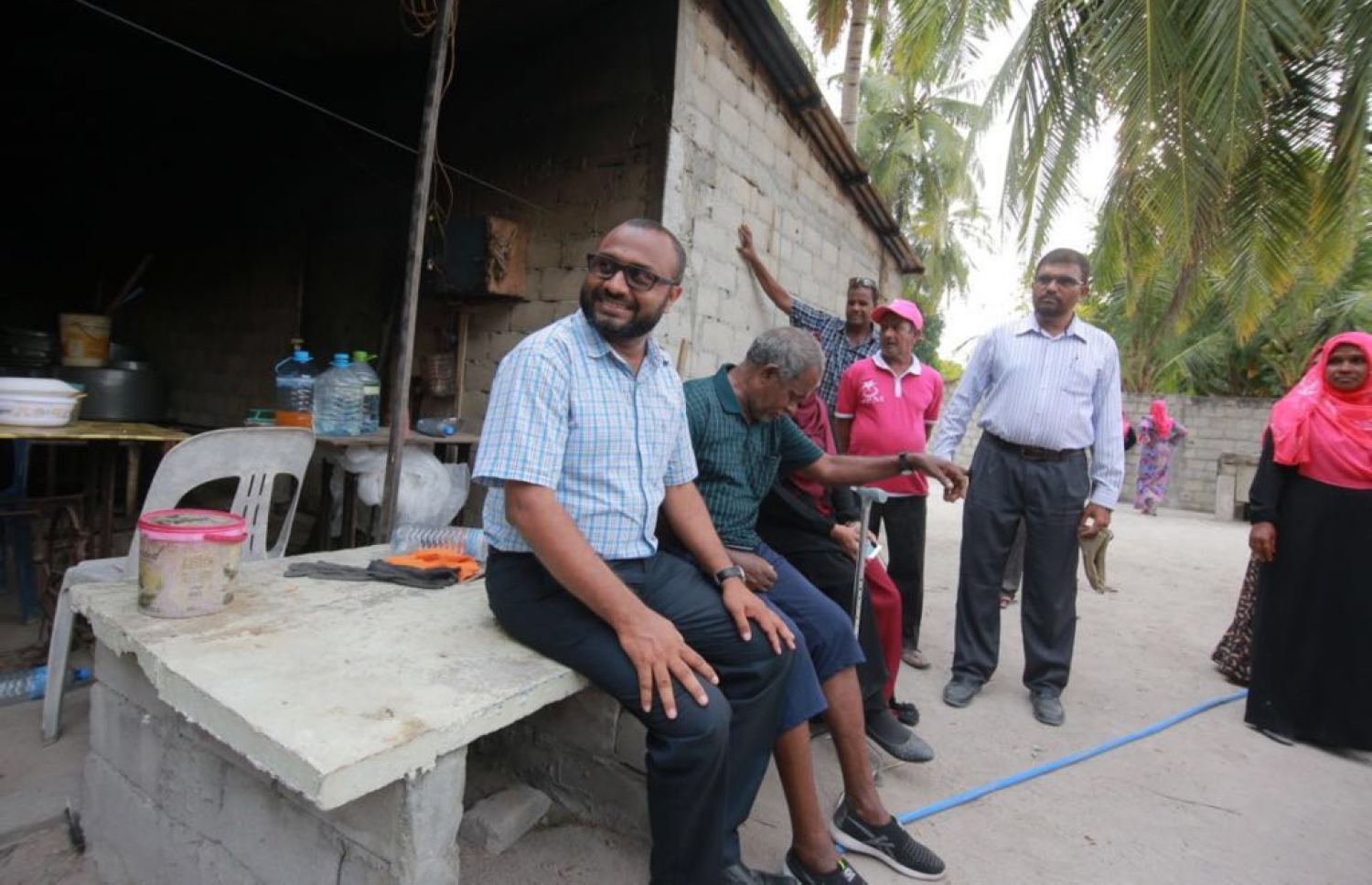 ޝަހީމް ރަށަކަށް ވަޑައިގެން އެރަށުގެ ގެއެއްގެ ބޭރުގައި ތިބި ބަޔަކާ ވާހަކަ ދައްކަވަނީ.---ފޮޓޯ: ޕީޕީއެމް