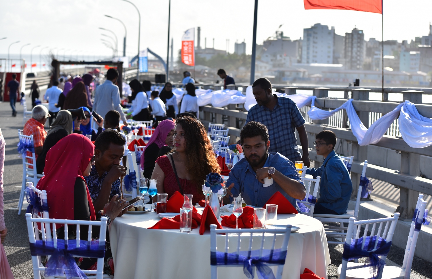 ބްރިޖުމަތީގައި މިއަދު ހަވީރު ކައިވެނި ކުރުމަށްޓަކައި ޒީނަތްތެރިކޮށްފައިވާ ސަރަހައްދުގައި  ބައެއް އާއިލާތައް މަޑުކޮށްލައިގެން.--- ފޮޓޯ: އަހުމަދު ނިޝާތު/މިހާރު