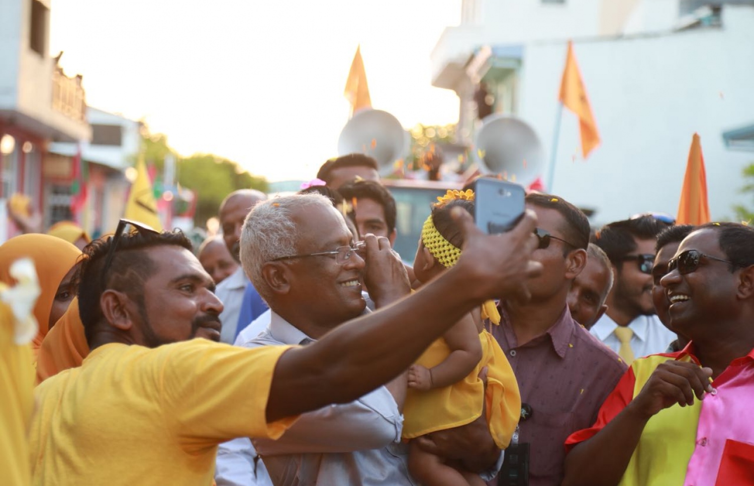 އިބޫ ކުޑަ ކުއްޖަކު އުރާލައްވައިގެން ހުންނެވިއިރު، މީހަކު ސެލްޕީއެއް ނަގަނީ.