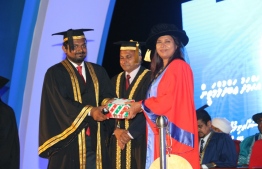 Minister of Education Aishath Shiham (R) presents the presidential award to Ahmed Abdul Matheen, who topped the Masters of Law course, at the MNU Graduation 2018.