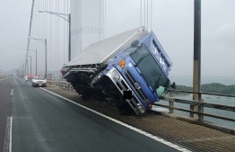 This handout photo released by the Kagawa Prefectural Police on September 4, 2018 and received via Jiji Press shows a truck sitting at an angle after being blown over by strong winds caused by Typhoon Jebi on the Seto Ohashi bridge in Sakade, Kagawa prefecture on Japan's Shikoku island.
The strongest typhoon to hit Japan in 25 years made landfall on September 4, the country's weather agency said, bringing violent winds and heavy rainfall that prompted evacuation warnings. / AFP PHOTO / JIJI PRESS AND Kagawa Prefectural Police / JIJI PRESS /  - Japan OUT / EDITOR'S NOTE: Car's licence plate was digitally blocked by Kagawa prefectural police
-----EDITORS NOTE --- RESTRICTED TO EDITORIAL USE - MANDATORY CREDIT "AFP PHOTO / Kagawa prefectural police " - NO MARKETING - NO ADVERTISING CAMPAIGNS - DISTRIBUTED AS A SERVICE TO CLIENTS / 